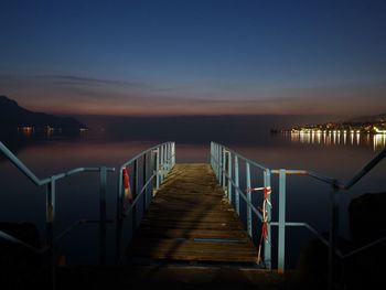 Pier over sea against sky at night