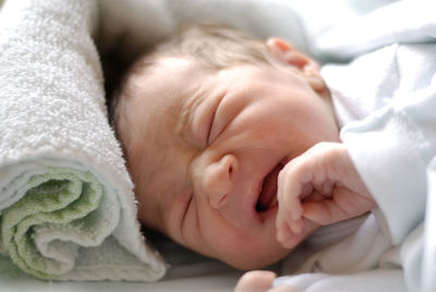 Close-up of cute baby sleeping on bed at home