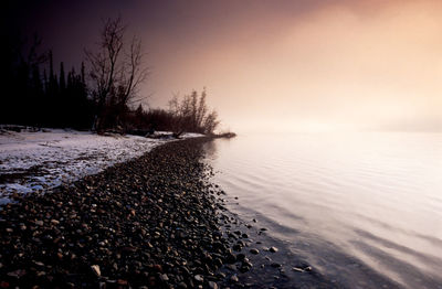 Scenic view of snow covered land against sky during sunset