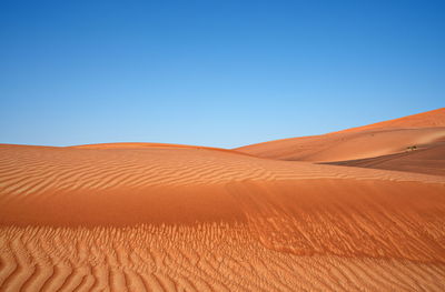 Scenic view of desert against clear blue sky