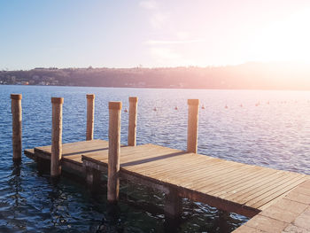 Pier on sea against sky during sunset