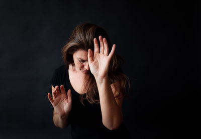 Portrait of a woman against black background