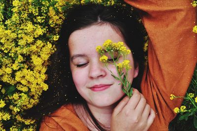 Portrait of smiling girl with yellow flower