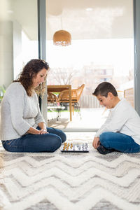 Mother and son playing chess at home