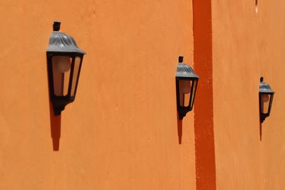 Scenic view of street lights next to orange wall
