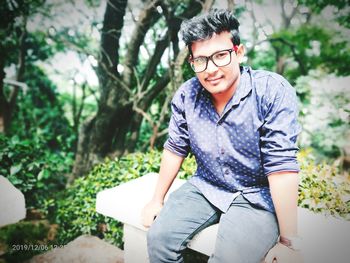 Portrait of smiling young man sitting outdoors