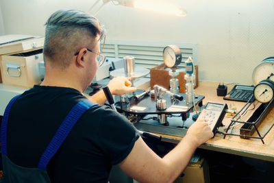 Side view of young man using laptop at home