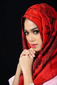 Portrait of beautiful young woman against black background