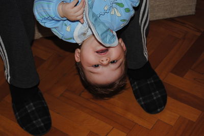 Portrait of cute boy relaxing on hardwood floor at home