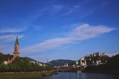 River amidst buildings against blue sky