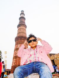 Low angle view of man sitting against sky