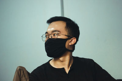 Portrait of young man against wall