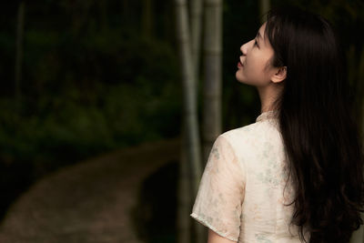 Side view of young woman standing outdoors