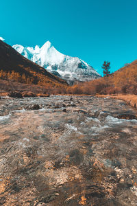 Scenic view of snowcapped mountains against clear blue sky