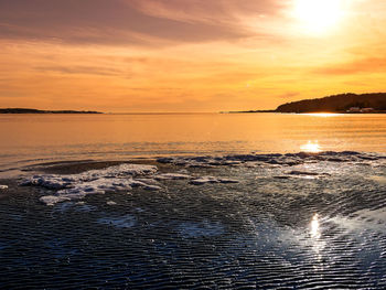 Scenic view of sea against dramatic sky during sunset