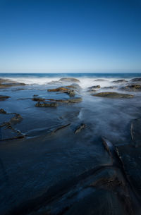 Scenic view of sea against clear blue sky