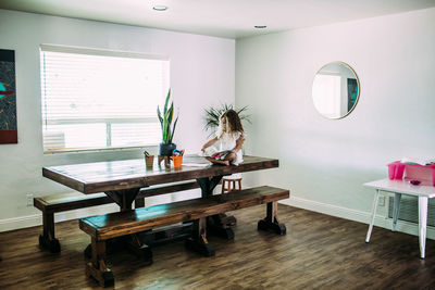 Young girl sitting on table reading alone