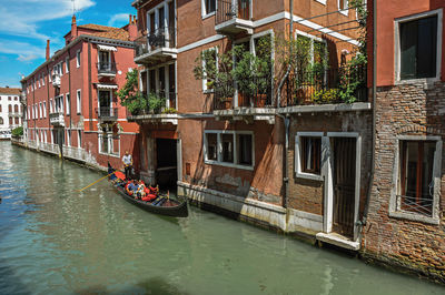 Buildings in front of the canal with gondola in venice, italy.