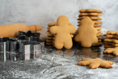 Baked christmas gingerbread in various shapes on a table sprinkled with flour.