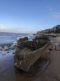 Rocks on beach against sky