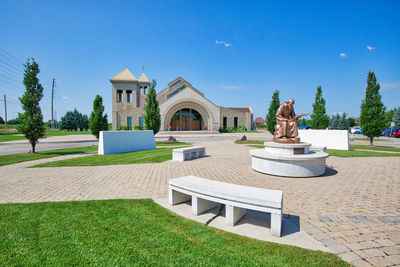 Sculpture by building against blue sky