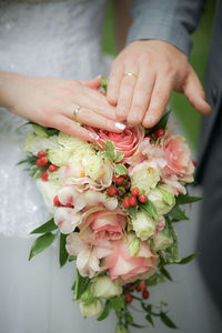 Close-up of hand holding rose bouquet