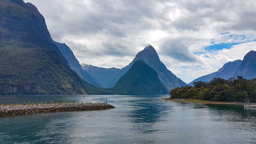 Scenic view of lake by mountains against sky