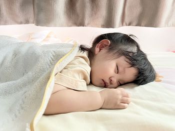 Cute baby boy sleeping on bed at home