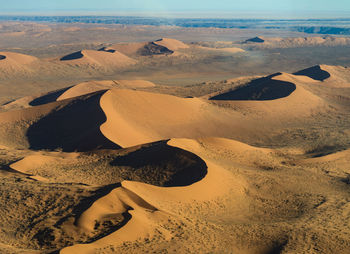 Scenic view of sand dunes in desert against sky