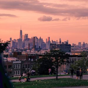 Modern buildings against sky in city at sunset