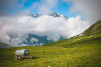 Scenic view of field and moutain range in alps against sky