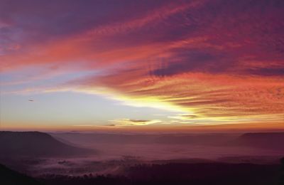 Scenic view of dramatic sky over silhouette landscape