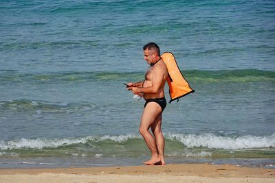 Portrait of young man standing at beach