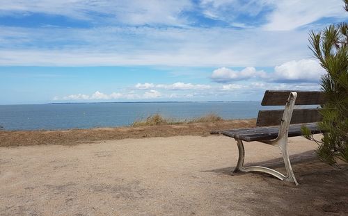 Chairs on beach against sky