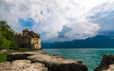 Scenic view of sea by buildings against sky