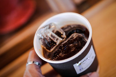 Close-up of hand holding coffee cup