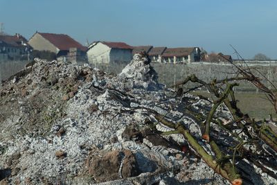 Houses by buildings against clear sky