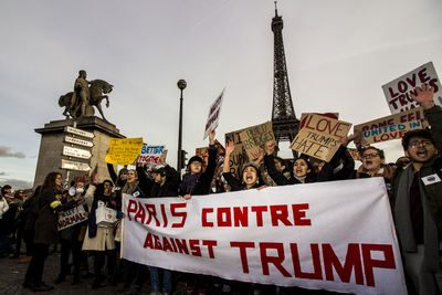 Group of people on street in city against sky