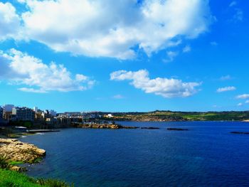 City by sea against blue sky