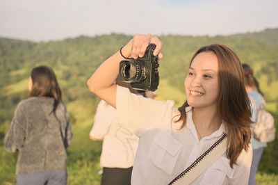 Young woman photographing with camera