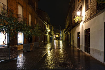 Illuminated walkway in city at night