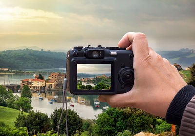 Man photographing on mountain against sky