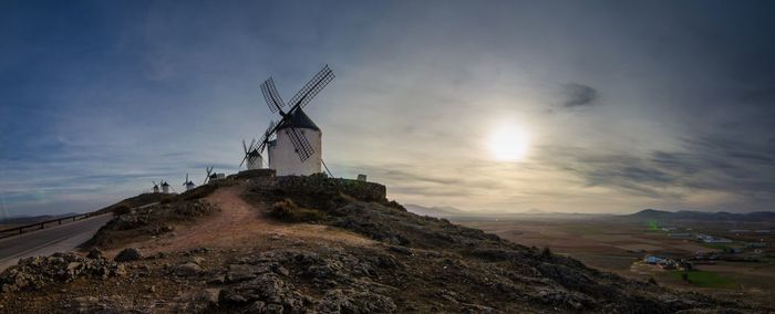 Traditional windmill on mountain against sky