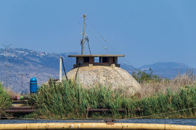 Traditional windmill on field against clear blue sky