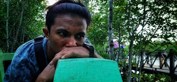 Portrait of young man against plants