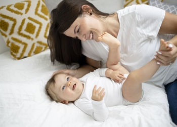 High angle view of mother and daughter on bed at home