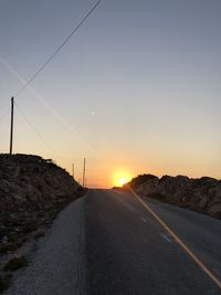 Country road against sky during sunset