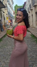 Portrait of smiling young woman in city