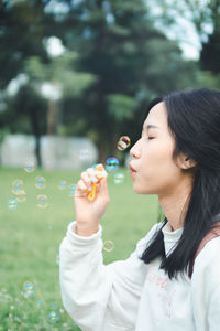 Young woman blowing bubbles