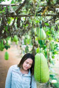 High angle view of young woman standing by gourd at farm